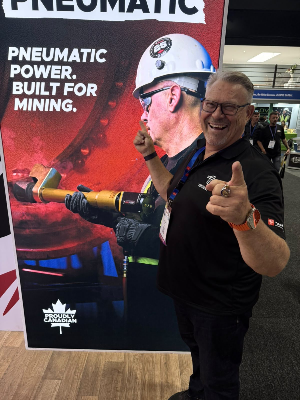 Titeforce team member in front of the RAD Pneumatic Built for Mining banner
